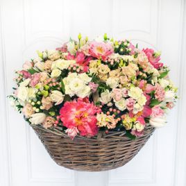 Корзина цветов с коралловыми пионами и кустовыми розами