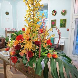 Корзина цветов с протеями, орхидеями, амарантом и форзицией