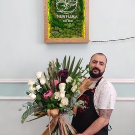 Экзотический букет роз с протеей с ветками пальмы и листьями банана