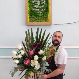 Экзотический букет роз с протеей с ветками пальмы и листьями банана
