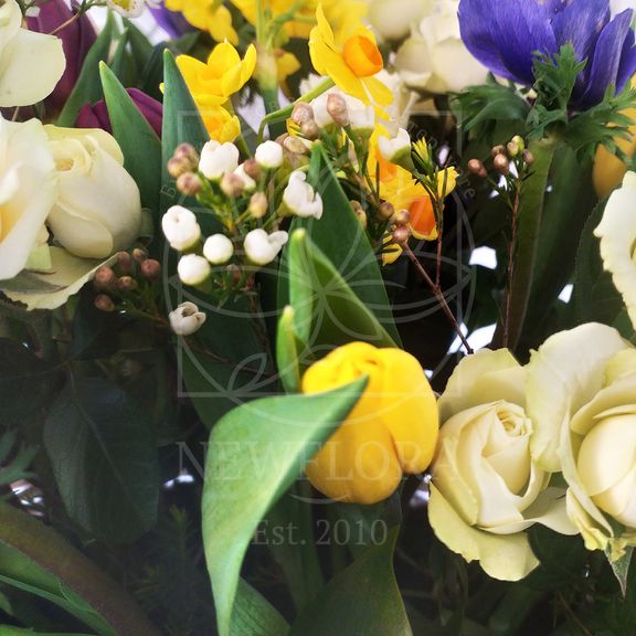 Корзина цветов с нарциссами, анемонами, тюльпанами и зеленью