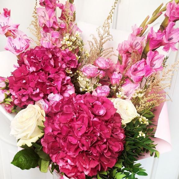 Букет розовых гладиолусов с астильбой и пионовидными розами