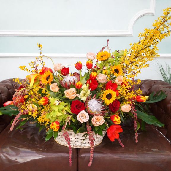 Корзина цветов с протеями, орхидеями, амарантом и форзицией
