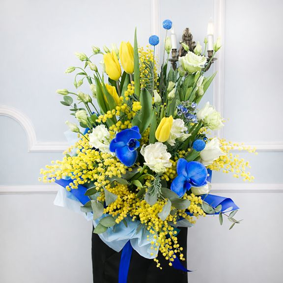 Букет из тюльпанов с мимозой, лизиантусом, оксипеталумом, краспедией и орхидеей