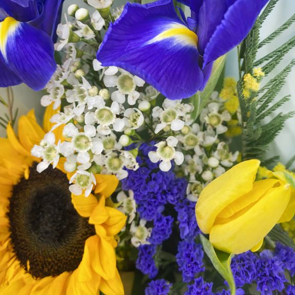 Букет из тюльпанов с ирисами, подсолнухом, мимозой и ваксфлауэр