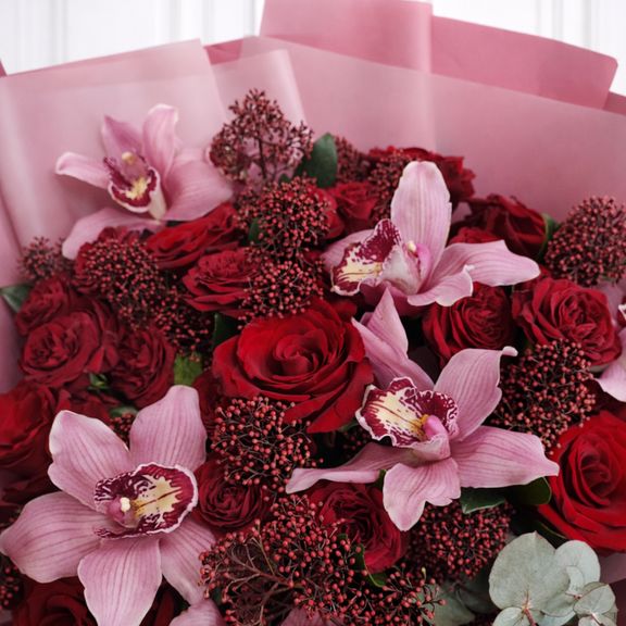 Букет красных роз с орхидеями, эвкалиптом и скиммией
